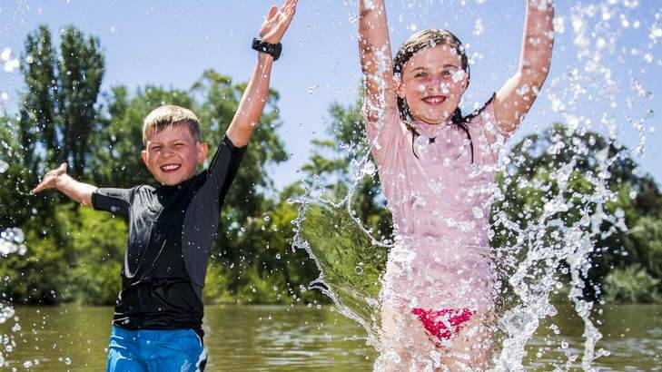 CHILLING: Roman (7) and Teah (9) Smith, from Duffy, cool down in the lake at Weston Park on Monday. Photo: Rohan Thomson