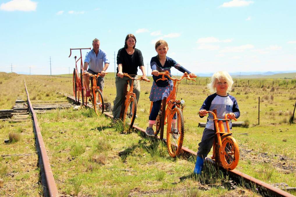 Will Jardine and his wife Caroline and two children Izzy, 6, and Jack, 3, pose on bikes on the old railway line between Cooma and Nimmitabel. Photo: Dave Moore