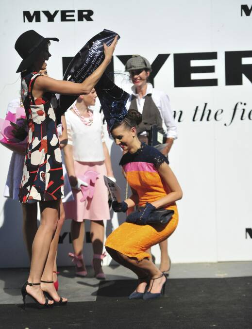 The height of fashions on the field winner Alice Anderson's hat meant chief judge Kate Peck had to struggle to place her sash on. Photo: Melissa Adams