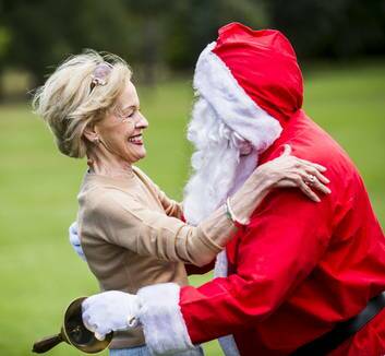 The Governor General Quentin Bryce gives Santa a welcome hug as he arrives at the Children?s Christmas Party at Government House on Wednesday. Photo: Rohan Thomson