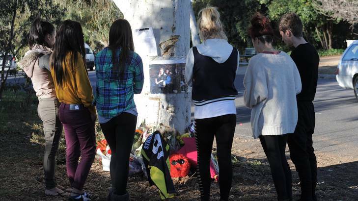 Scene of this morning's fatal accident on Eggleston Crescent, Chifley. School friends from Stromlo High, gather at the tree where the car hit. Photo: Graham Tidy