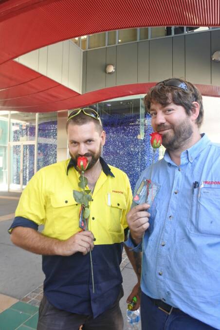 Dean Bissett and Scott Taylor were happy to receive a rose on Valentine's Day from Sexual Health and Family Planning ACT. Photo: Megan Doherty