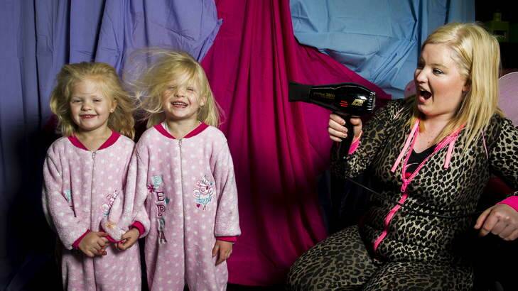 Twins, Brydie and Kaleigh Duve, 5, are dried with a hairdryer by Arielle Martin at Numero Uno in Queanbeyan, which held a onesies day on Friday. Photo: Rohan Thomson