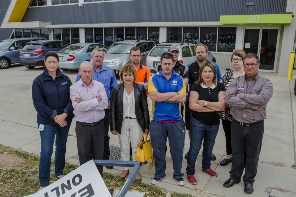 Some of the Hume business owners who are considering a class action against Telstra after they lost internet services for more than a week. They are outside a business vandalised when security cameras and systems connected through the internet failed. Photo: Jamila Toderas