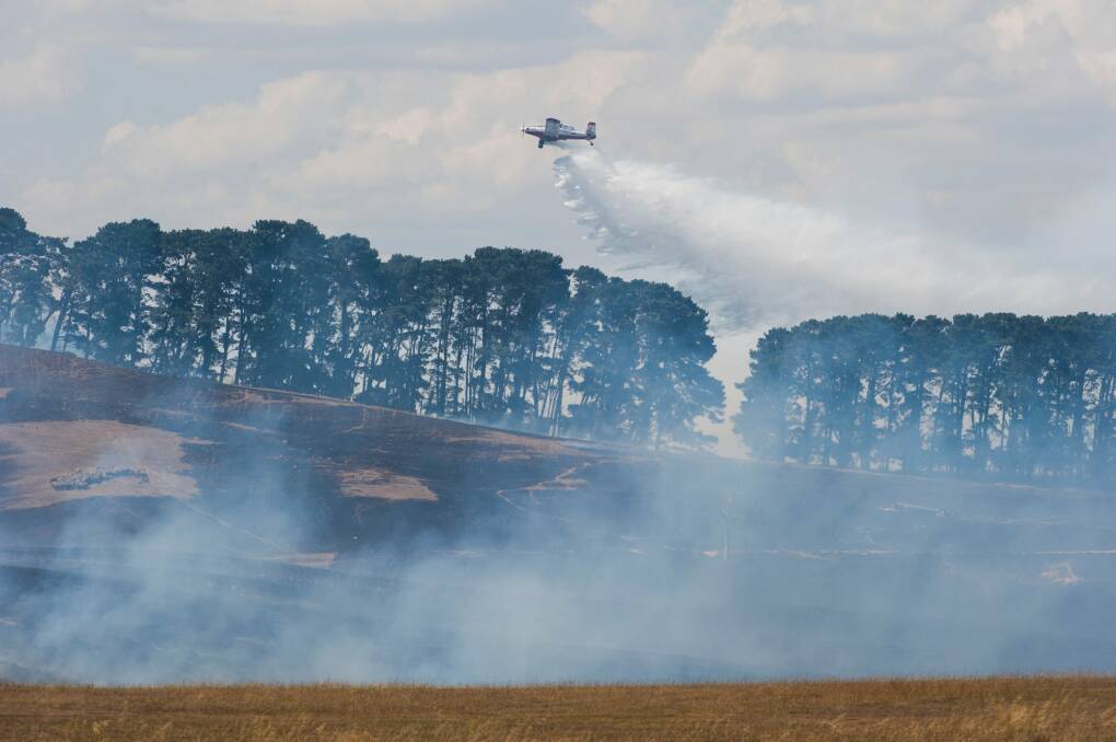 A plane dumps water over the Tarago fire on Tuesday. Photo: Elesa Kurtz