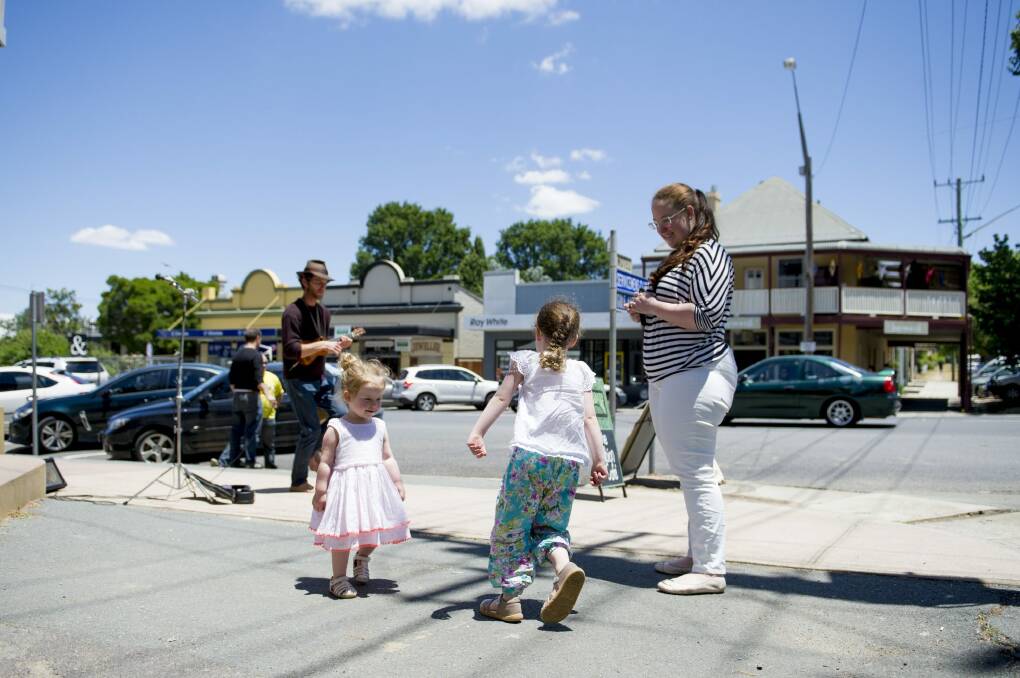 Rebecca Carpenter and her daughters Eliza, 4, and Victoria, 2, dance  in the streets of Braidwood to burn off some energy on the trip to the coast.
 Photo: Jay Cronan