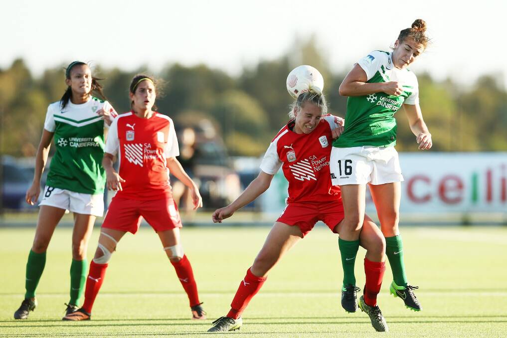 Grace Abbey of Adelaide competes with Canberra United's Tegan Riding for the ball. Photo: Morne de Klerk