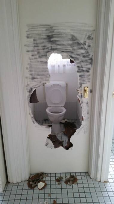A giant hole smashed in the door to the toilet at the Kambah house. Photo: Megan Gorrey
