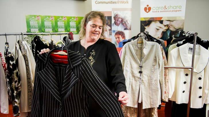 Maree Miller, past client, and now volunteer of the communities at work program, with one of the suits donated by Labor MPs, a Carla Zampatti suit, believed to be owned by Julia Gillard. Photo: Rohan Thomson
