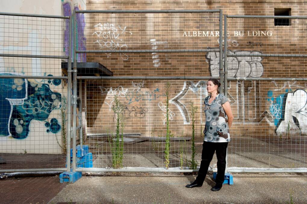 Woden Valley Community Council president Fiona Carrick in front of some of Woden's derelict buildings. The Woden community is banking on light rail for urban renewal. Photo: Jay Cronan