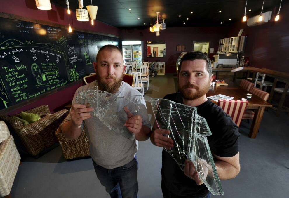 Co-owners of Eat me Drink me at the Kaleen shops and
former army buddies, Jay Logan and John Wellfare hold up glass shards from the break in. Photo: Graham Tidy