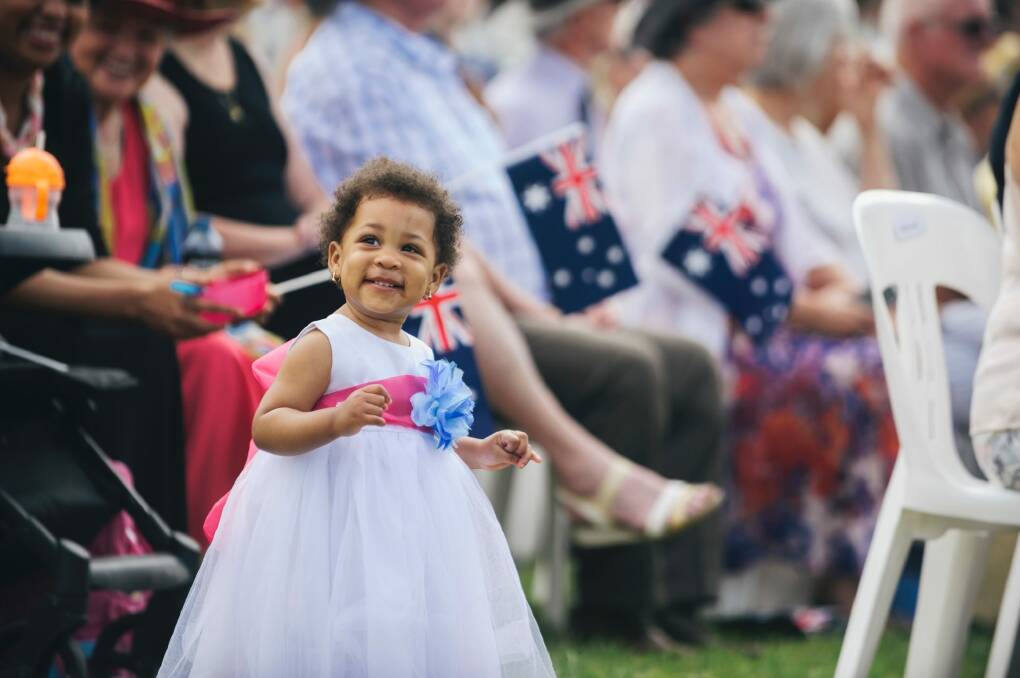 Fifteen-month-old Mikaela Udom, of Crace, happily danced to music from the Royal Military College Duntroon before her dad, Samuel, an architect from Nigeria, became an Australian citizen Photo: Rohan Thomson