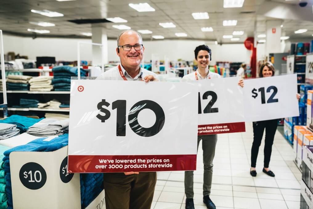 Target's Peter van Gestel, Bradley Chapman and Ann-Maree Miller with signage ahead of the boxing day sales. Photo: Rohan Thomson