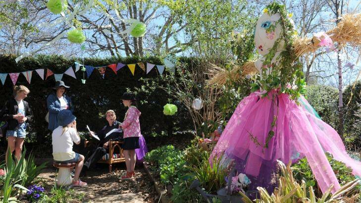 A fairy garden at Cowper Street attracted children, especially for book readings by Merlin. Astrid Walsh, 9, right, was on hand to help out in her parents garden. Photo: Graham Tidy
