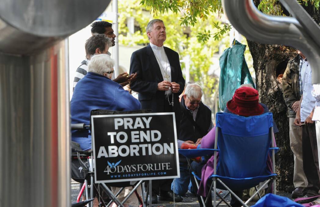 The Catholic Archbishop of Canberra and Goulburn, Christopher Prowse, leads a prayer vigil outside an abortion clinic in Civic in March. Photo: Graham Tidy