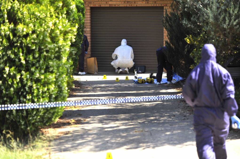 Forensic investigators process evidence in the driveway of the Wanniassa home where Neal Wilkinson was allegedly murdered. Photo: Jay Cronan