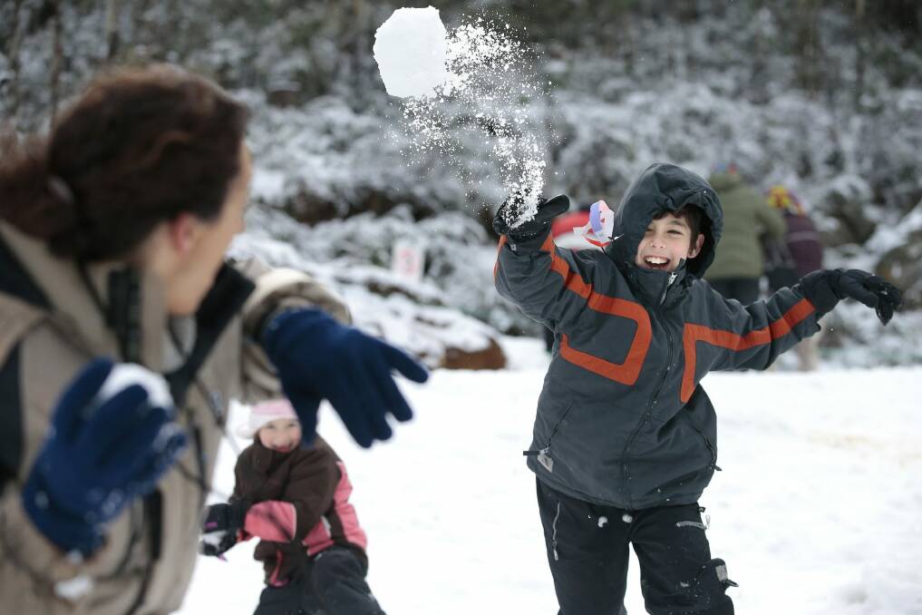 Snow at Corin Forest near Canberra.  from left, Lisa Hills of Sydney and Josh Hill, 9, having a snowball fight. Photo: Jeffrey Chan