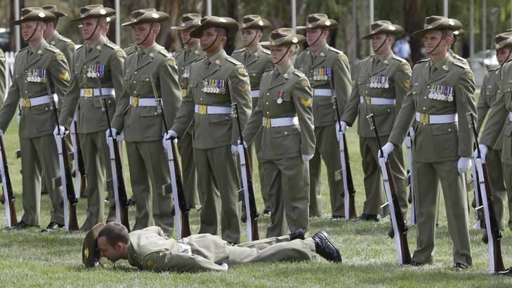 A Federation Guard member collapses during the Centenary of Canberra Foundation Stone ceremony. Photo: Andrew Meares