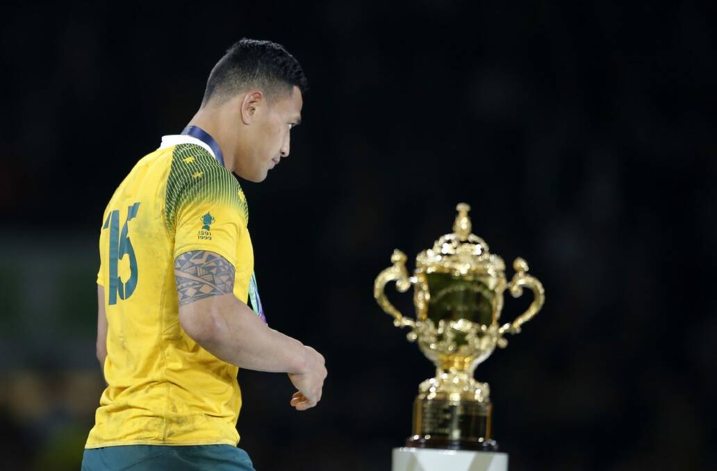 So close, yet so far: Israel Folau walks past the World Cup trophy after receiving his silver medal following Australia's loss to New Zealand. Photo: Frank Augstein