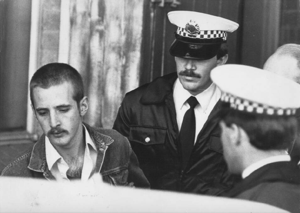 Julian Knight, left, being taken away by police after the Hoddle Street shooting.  Photo: John Lamb