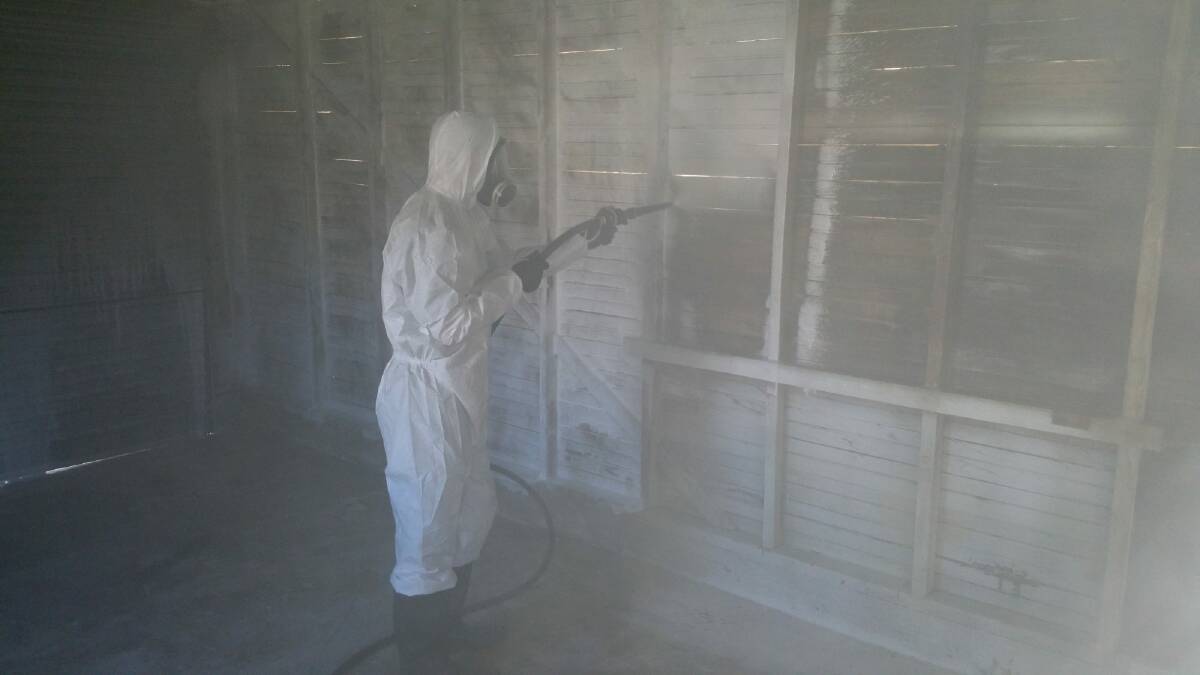 A cleaner decontaminating a garage with chemical foam. Photo: Meth Lab Cleaners Australia.