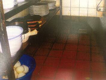 Unclean shelving and food containers stored on the floor. Photo: Supplied