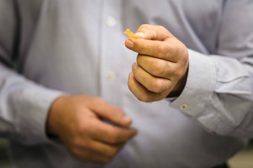 Intel supervisor Peter Robertson holds a wafer of the drug buprenorphine. Photo: Sitthixay Ditthavong