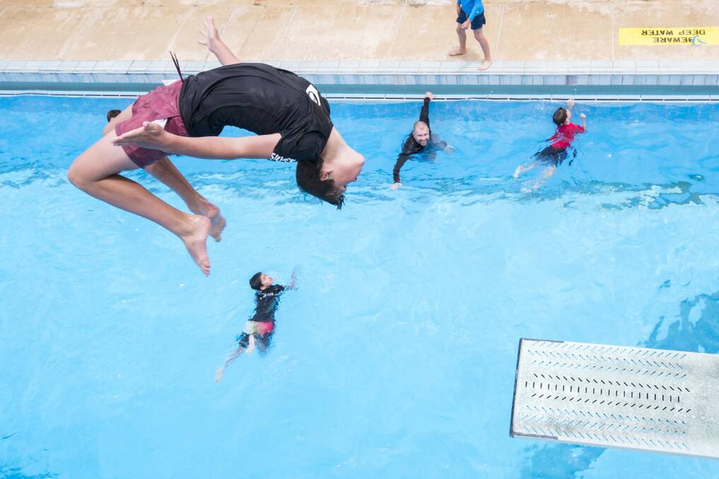 Harry Ward does a backflip off the diving board at Canberra Olympic Pool. Photo: Dion Georgopoulos
