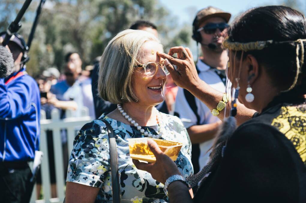 Lucy Turnbull is painted with ochre by Ngunnawal elder Tina Brown at the national citizenship ceremony in Canberra. Photo: Rohan Thomson