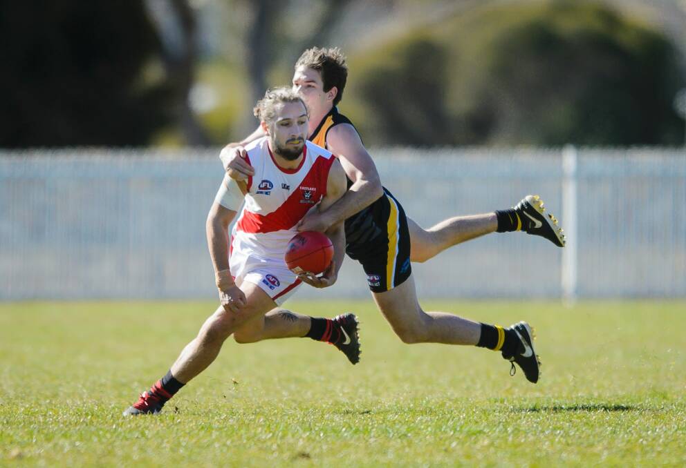 The Demons' Ciaran O'Rourke is tackled by the Tigers' Mitchell Price. Photo: Sitthixay Ditthavong