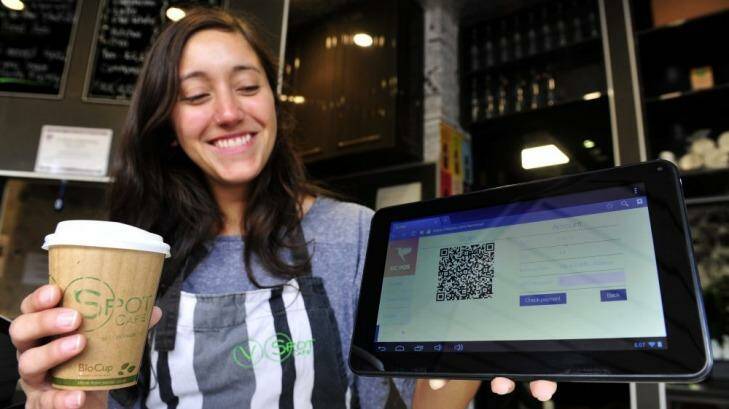V Spot Cafe assistant manager Monica Furastec Danilevicz shows how the cafe accepts bitcoin payment. Photo: Melissa Adams