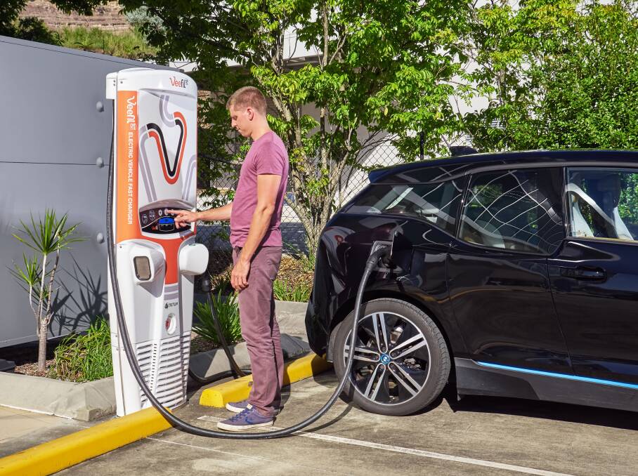 A man charges his electric car at a Tritium fast-charging station. Photo: Supplied