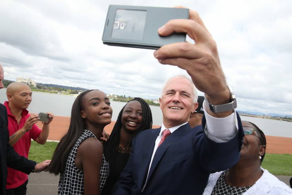 Prime Minister Malcolm Turnbull takes a selfie with new Australian citizens Lydia Banda-Mukuka and Chilandu Kalobi Chilaika. Photo: Andrew Meares