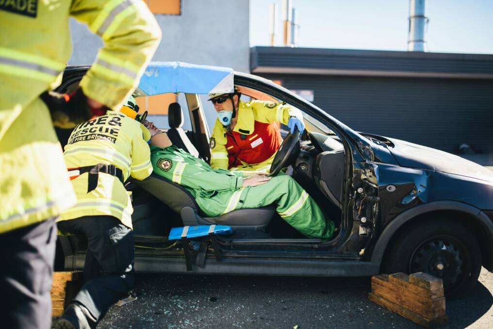 The 'victim' lies flat as the crew prepares to remove him from the car. Photo: Rohan Thomson