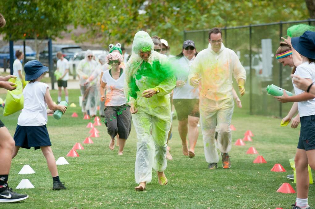 Radford College principal Fiona Godfrey and head of junior school Paul Southwell get pelted in the school's own colour run on Thursday. Photo: Jonquil Mackey