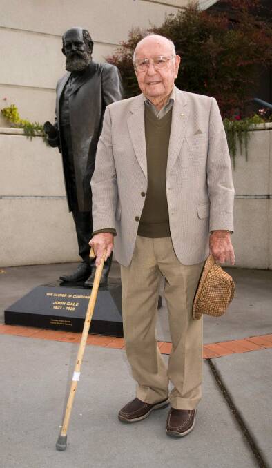 Prominent newspaper man Jim Woods, at age 100, standing in front of the Queanbeyan statue of John Gale (founder of The Queanbeyan Age newspaper). Photo: Queanbeyan- City of Champions