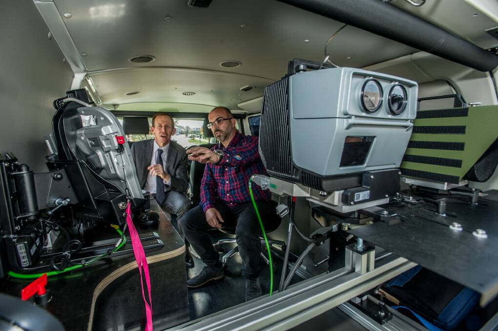Traffic camera office shift supervisor Tony Taseski shows road safety minister Shane Rattenbury the kit in the back of a mobile speed camera. Photo: Karleen Minney