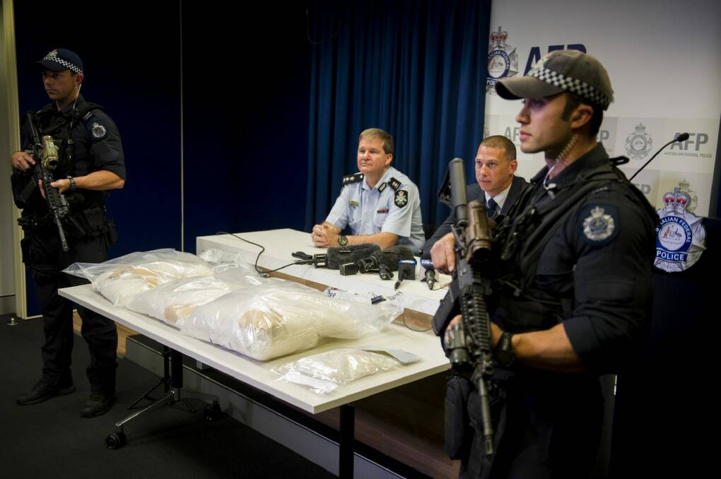 Acting Commander Paul Shakeshaft and Detective sergeant Shane Scott address the media, while armed police guard the drugs. Photo: Jay Cronan