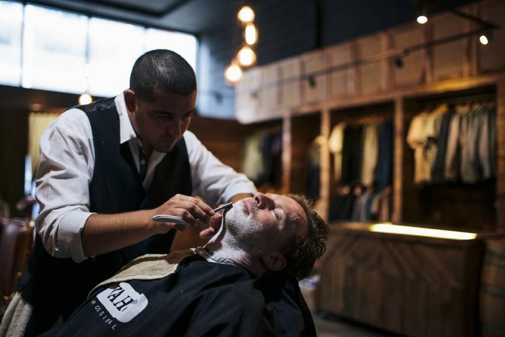 Barber Steve Carbone shaving client Kel Watt. Photo: Rohan Thomson