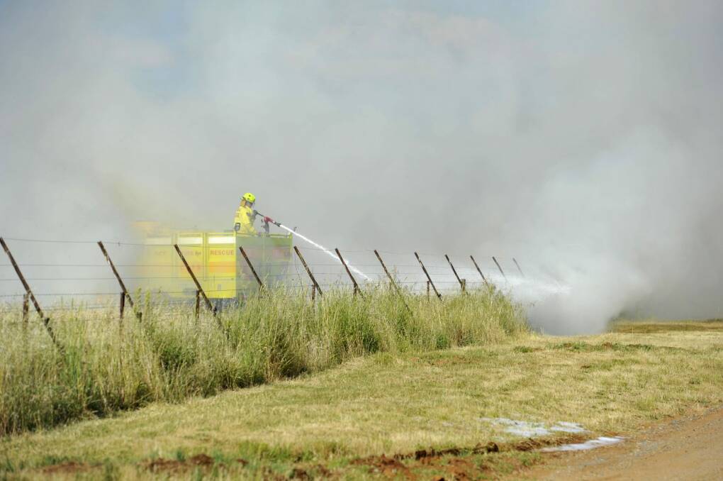 Fire crews put out a small grass fire on majura road near the airport in November 2014. 
 Photo: Jay Cronan
