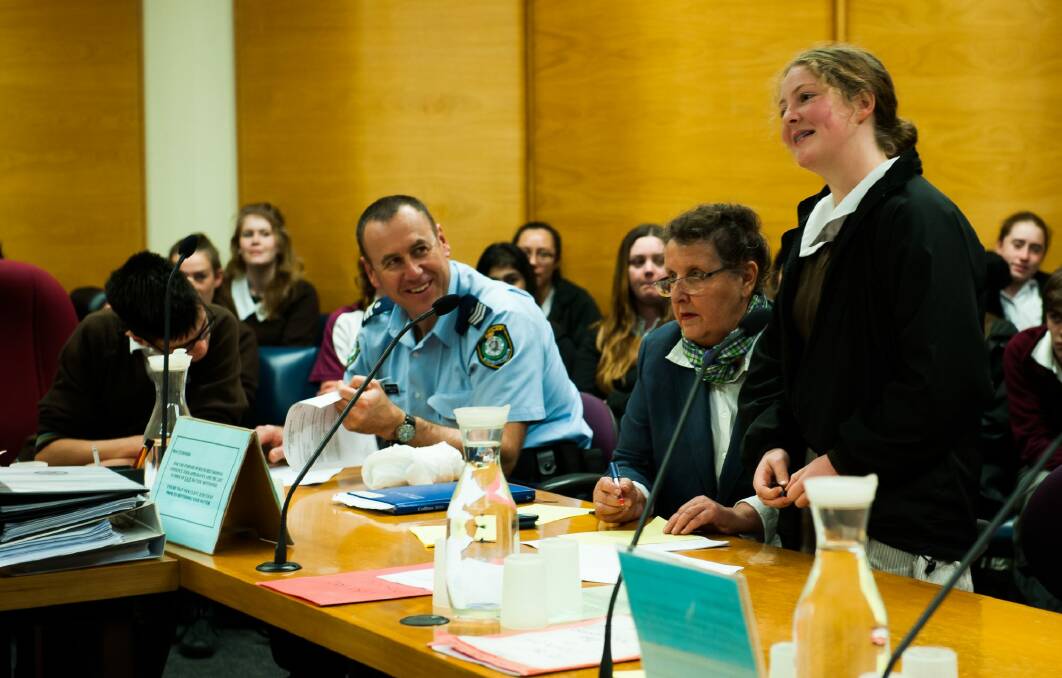 Queanbeyan and Karabar High School students, Jack Dempsey and Caitlin Oats with guidance from Sergeant Dominic Goodyear and solicitor Rosemary Benet, take part in a mock court trial of drug and alcohol charges at Queanbeyan Local Court. Photo: Elesa Kurtz
