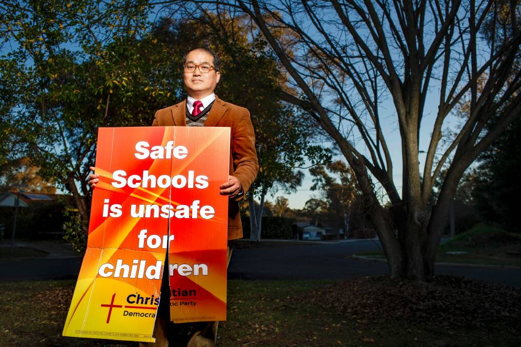 Rev. David Kim with one of the ACT Christian Democratic Party's anti safe schools campaign signs after it had been vandalised at his home.  Photo: Sitthixay Ditthavong