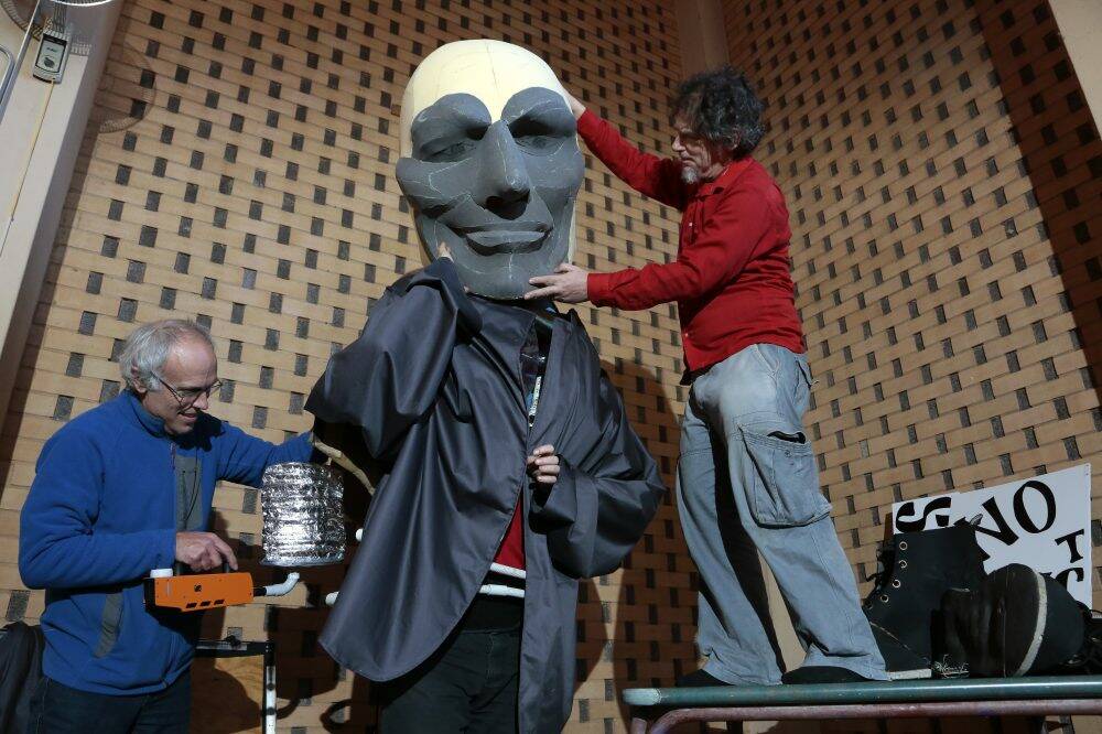From left, concept instigator Matthew Armstrong, performer Hemlock Mejarne (masked) and director Robin Davidson work on the final touches on a Tony Abbott puppet. Photo by Jeffrey Chan.