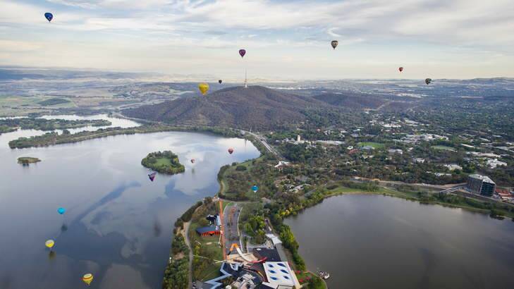 Hot air balloons soar above Lake Burley Griffin, with the National Museum of Australia in the foreground. Photo: Rohan Thomson