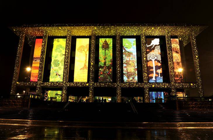 The National Library of Australia is illuminated for the Enlighten Festival. by a  giant light projection. A small number of people braved torrential rain for a glimpse. The artist who created the projection was Paul Summerfield. Photo: STUART WALMSLEY