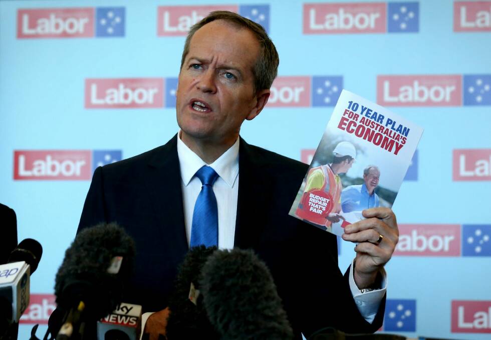 Mr Shorten with the Labor Party's election booklet.  Photo: Alex Ellinghausen