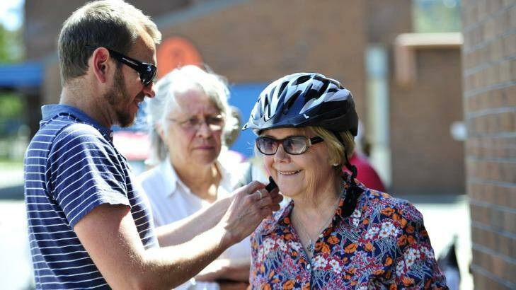Carol Walker of Kingston has a helmet fitted by Pedal Power project manager, Stuart Jones during Pedal Power ACT's "Come n Try Day" at Melrose High School. Photo: Melissa Adams
