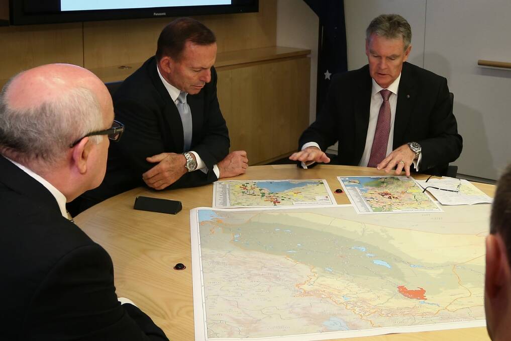Prime Minister Tony Abbott and ASIO director-general Duncan Lewis look at the secret-but-not secret maps at ASIO Headquarters on Wednesday. Photo: Alex Ellinghausen
