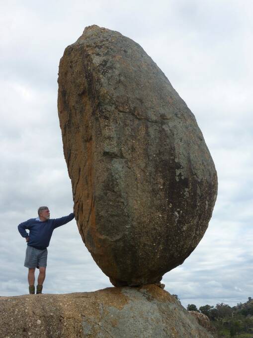 John Baker "holds up" his Balancing Rock near Canberra. Photo: Tim the Yowie Man