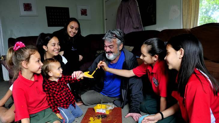 Indigenous dad Peter Finegan doing traditional dot art with his kids. Photo: Melissa Adams